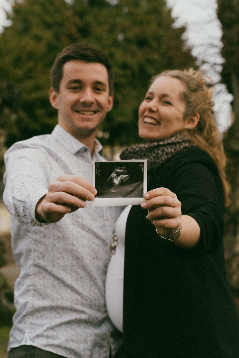Laura und Marcel zeigen stolz ein Ultraschall-Bild beim Babybauch Fotoshooting